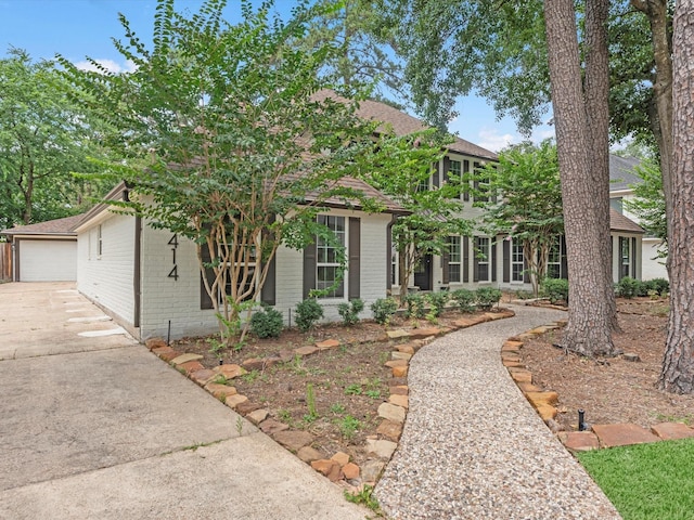 9414 Stockport Dr, Spring, TX 77379 - view of front of property featuring brick siding, an outbuilding, a garage, and a shingled roof