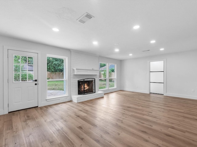9414 Stockport Dr, Spring, TX 77379 - unfurnished living room featuring light wood-style floors, a brick fireplace, recessed lighting, and baseboards