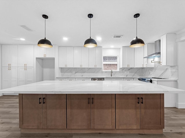 9414 Stockport Dr, Spring, TX 77379 - kitchen with wall chimney range hood, light wood finished floors, white cabinetry, backsplash, and recessed lighting