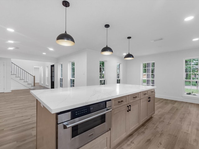 9414 Stockport Dr, Spring, TX 77379 - kitchen featuring stainless steel oven, light wood finished floors, recessed lighting, hanging light fixtures, and a center island