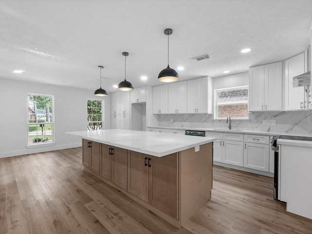 9414 Stockport Dr, Spring, TX 77379 - kitchen with light wood-type flooring, electric stove, decorative backsplash, white cabinetry, and recessed lighting
