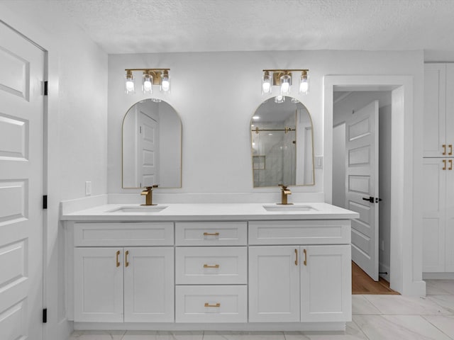 9414 Stockport Dr, Spring, TX 77379 - full bathroom featuring a stall shower, marble look tile flooring, a textured ceiling, and double vanity