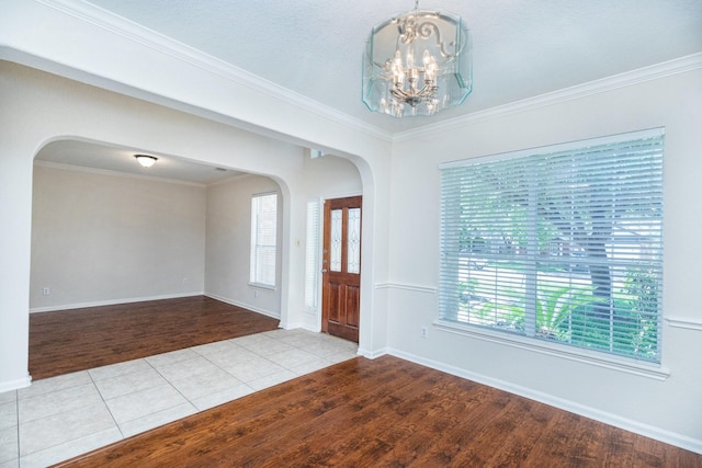 4126 Winesap Bend Dr, Stafford, TX 77477 - foyer with arched walkways, a chandelier, wood finished floors, baseboards, and ornamental molding