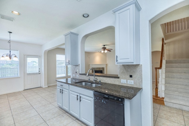 4126 Winesap Bend Dr, Stafford, TX 77477 - kitchen with black dishwasher, a sink, a ceiling fan, arched walkways, and a fireplace