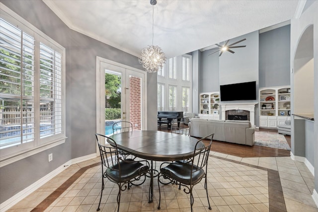 22719 Arbor Stream Dr, Katy, TX 77450 - dining space featuring plenty of natural light, inlaid floor details, a fireplace, crown molding, and a high ceiling