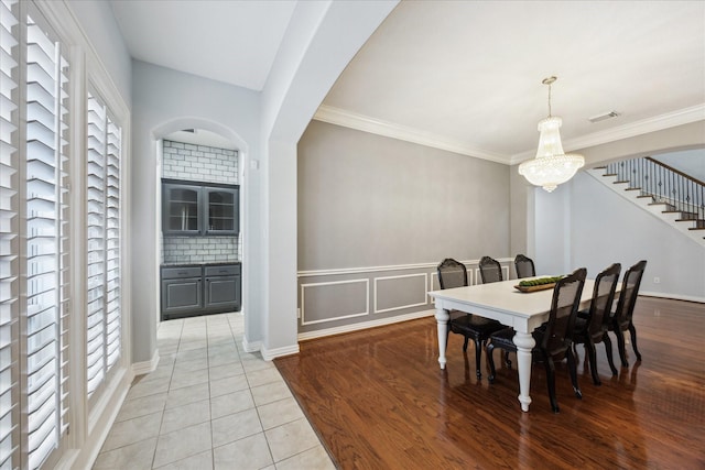 22719 Arbor Stream Dr, Katy, TX 77450 - dining area featuring plenty of natural light, stairs, a chandelier, arched walkways, and ornamental molding