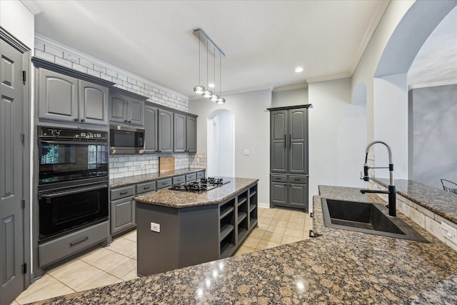 22719 Arbor Stream Dr, Katy, TX 77450 - kitchen with a sink, black gas stovetop, double oven, arched walkways, and stainless steel microwave