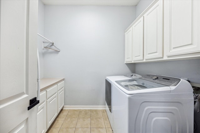 22719 Arbor Stream Dr, Katy, TX 77450 - washroom featuring washing machine and clothes dryer, cabinet space, light tile patterned floors, and baseboards