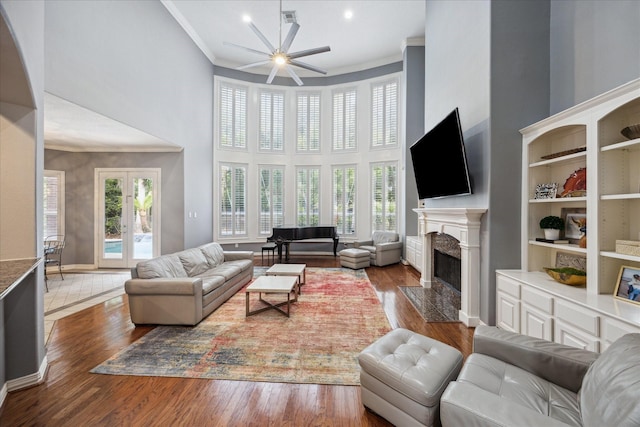 22719 Arbor Stream Dr, Katy, TX 77450 - living room with a high end fireplace, a towering ceiling, ceiling fan, wood finished floors, and crown molding