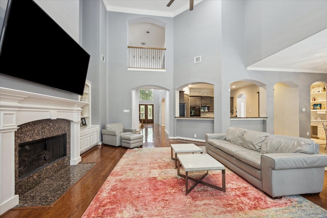 22719 Arbor Stream Dr, Katy, TX 77450 - living area with wood finished floors, a premium fireplace, crown molding, built in shelves, and ceiling fan