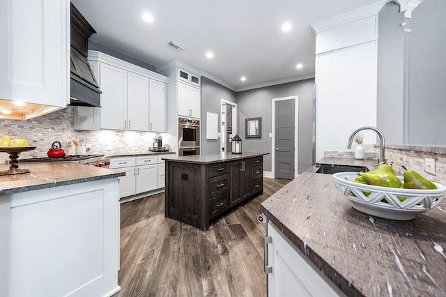 4322 Cannondale Ln, Katy, TX 77450 - kitchen with backsplash, stainless steel double oven, ornamental molding, white cabinets, and a kitchen island