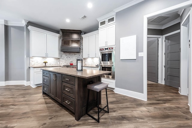 4322 Cannondale Ln, Katy, TX 77450 - kitchen with double oven, baseboards, ornamental molding, white cabinetry, and recessed lighting