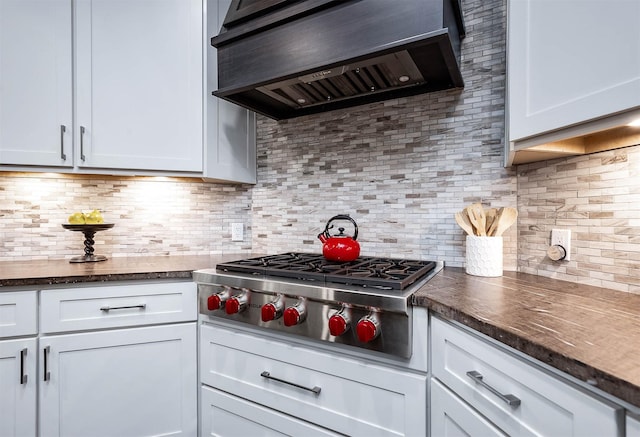 4322 Cannondale Ln, Katy, TX 77450 - kitchen with ventilation hood, stainless steel gas cooktop, dark countertops, backsplash, and white cabinets