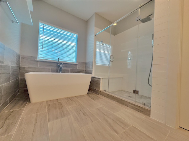 418 Yale Oaks Ln, Houston, TX 77091 - bathroom with tile walls, a stall shower, and a freestanding tub