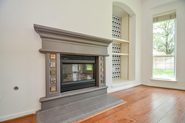 7919 Clarion Way, Houston, TX 77040 - detailed view of wood finished floors, baseboards, and a glass covered fireplace