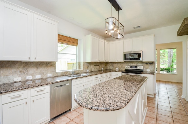7919 Clarion Way, Houston, TX 77040 - kitchen with appliances with stainless steel finishes, a sink, light tile patterned floors, tasteful backsplash, and white cabinets