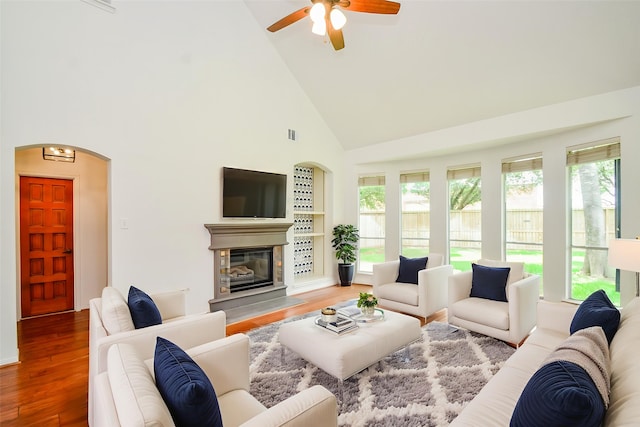 7919 Clarion Way, Houston, TX 77040 - living room with high vaulted ceiling, arched walkways, ceiling fan, wood finished floors, and a glass covered fireplace