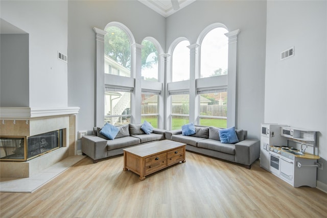 14130 Glasgow Pl, Houston, TX 77077 - living room with a high ceiling, light wood finished floors, and a tiled fireplace