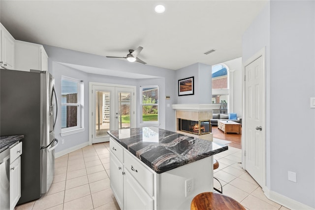 14130 Glasgow Pl, Houston, TX 77077 - kitchen featuring freestanding refrigerator, light tile patterned floors, a ceiling fan, white cabinets, and recessed lighting