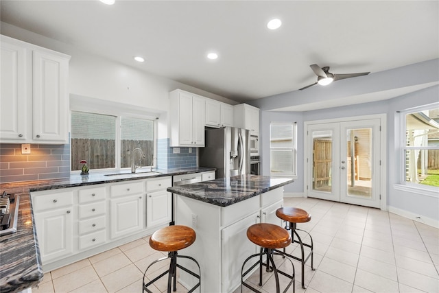 14130 Glasgow Pl, Houston, TX 77077 - kitchen featuring a sink, appliances with stainless steel finishes, a kitchen bar, light tile patterned floors, and tasteful backsplash