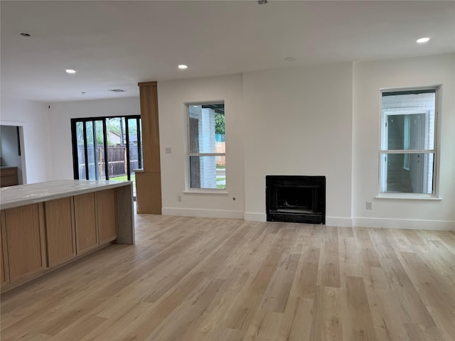 5005 Chestnut St, Bellaire, TX 77401 - unfurnished living room with light wood-type flooring, a fireplace, baseboards, and recessed lighting