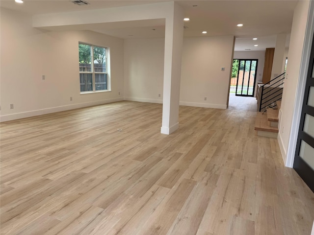 5005 Chestnut St, Bellaire, TX 77401 - empty room with healthy amount of natural light, light wood finished floors, recessed lighting, baseboards, and stairway