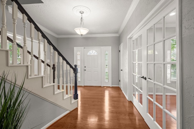 16907 Misty Creek Dr, Spring, TX 77379 - foyer with french doors, wood finished floors, stairs, a textured ceiling, and crown molding