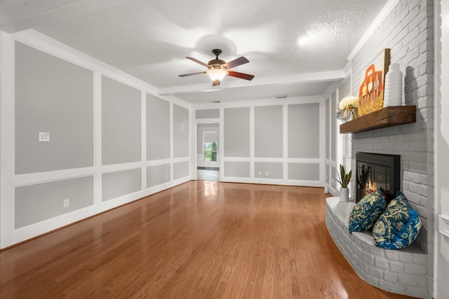 16907 Misty Creek Dr, Spring, TX 77379 - unfurnished living room featuring a brick fireplace, ceiling fan, wood finished floors, and crown molding