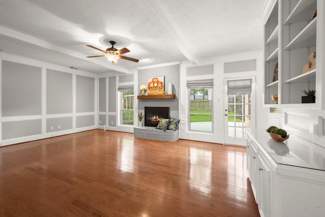 16907 Misty Creek Dr, Spring, TX 77379 - living area with a textured ceiling, a brick fireplace, a ceiling fan, and wood finished floors