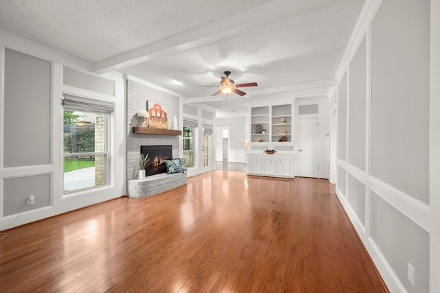 16907 Misty Creek Dr, Spring, TX 77379 - unfurnished living room with a fireplace, plenty of natural light, a textured ceiling, ceiling fan, and wood finished floors