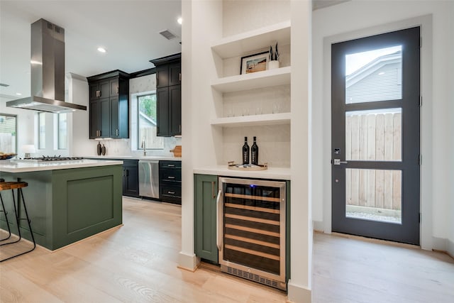 1724 Ridgewood St, Houston, TX 77006 - indoor dry bar with wine cooler, island range hood, light wood-type flooring, white gas cooktop, and stainless steel dishwasher