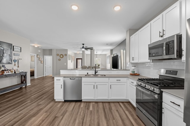 7315 Parkview Dr, Hitchcock, TX 77563 - kitchen with stainless steel appliances, a sink, a peninsula, ceiling fan, and backsplash