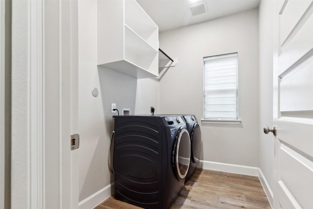 11439 Bush Clover Dr, Cypress, TX 77433 - laundry room with independent washer and dryer, light wood finished floors, and baseboards