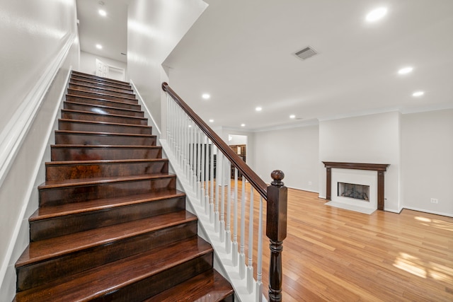 4023 Breakwood Dr, Houston, TX 77025 - stairway with wood finished floors, recessed lighting, crown molding, a fireplace with flush hearth, and baseboards