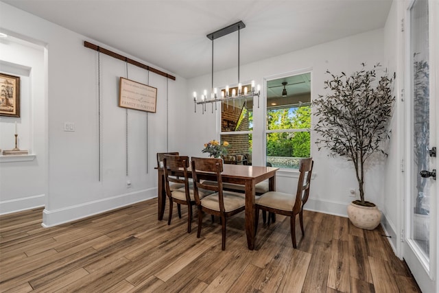 308 Lane Landing Pl, Montgomery, TX 77316 - dining area with wood finished floors, a chandelier, and baseboards