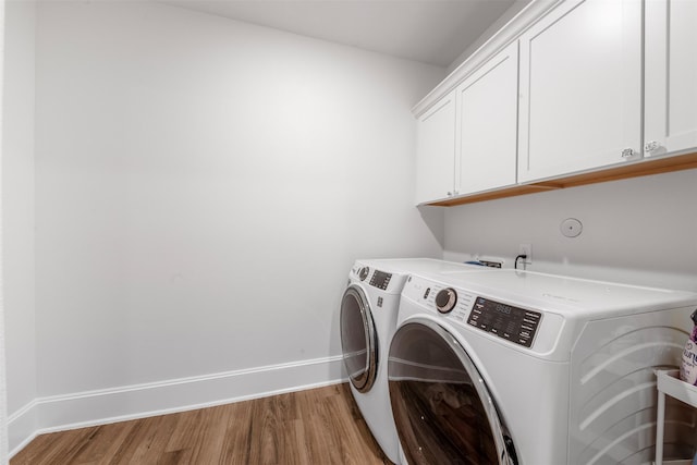 308 Lane Landing Pl, Montgomery, TX 77316 - laundry room featuring cabinet space, independent washer and dryer, light wood-type flooring, and baseboards
