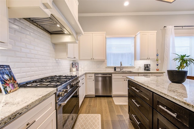 10918 Brookeshire Chase Ln, Houston, TX 77043 - kitchen with appliances with stainless steel finishes, a sink, white cabinets, crown molding, and recessed lighting