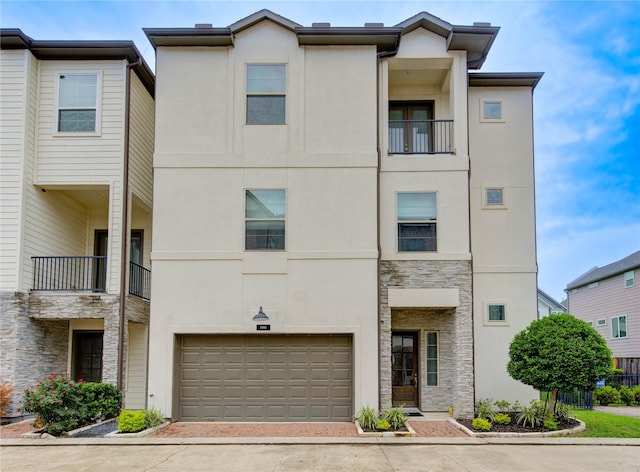 10918 Brookeshire Chase Ln, Houston, TX 77043 - view of front of home with stone siding, stucco siding, decorative driveway, an attached garage, and a balcony