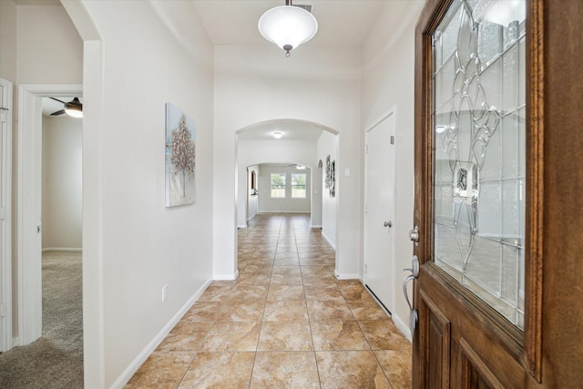 13303 Bomoseen Lake Rd, Houston, TX 77044 - foyer entrance featuring arched walkways, ceiling fan, baseboards, and light tile patterned floors