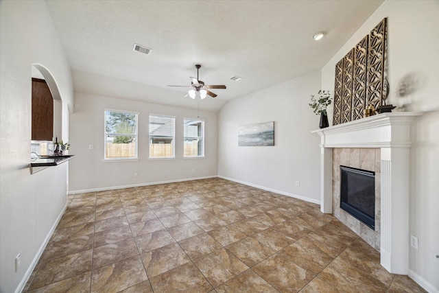 13303 Bomoseen Lake Rd, Houston, TX 77044 - unfurnished living room featuring a ceiling fan, a fireplace, lofted ceiling, baseboards, and stone finish floors
