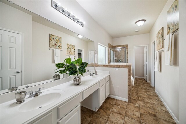 13303 Bomoseen Lake Rd, Houston, TX 77044 - full bathroom with a stall shower, double vanity, stone finish flooring, and baseboards