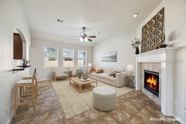 13303 Bomoseen Lake Rd, Houston, TX 77044 - living area with ceiling fan, a tiled fireplace, vaulted ceiling, and baseboards