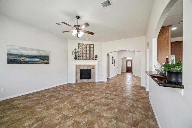 13303 Bomoseen Lake Rd, Houston, TX 77044 - unfurnished living room featuring a ceiling fan, arched walkways, a fireplace, baseboards, and recessed lighting
