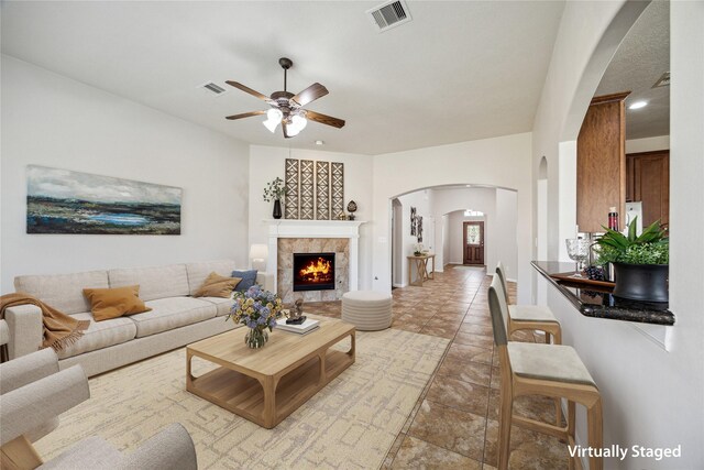 13303 Bomoseen Lake Rd, Houston, TX 77044 - living room with arched walkways, ceiling fan, and a tiled fireplace
