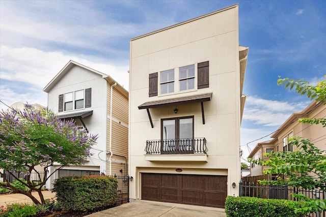 6110 Clyde St, Houston, TX 77007 - view of front facade featuring a balcony, an attached garage, concrete driveway, and stucco siding