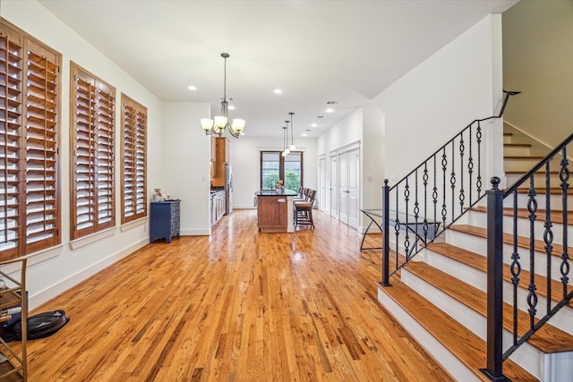 6110 Clyde St, Houston, TX 77007 - unfurnished living room with light wood-style floors, baseboards, a chandelier, stairway, and recessed lighting