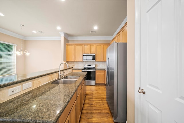 2804 Sherwin St, Houston, TX 77007 - kitchen with appliances with stainless steel finishes, a sink, wood finished floors, crown molding, and decorative backsplash