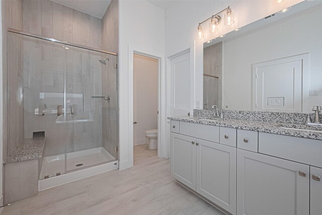 21307 Metallic Blue Dr, Cypress, TX 77433 - bathroom with toilet, double vanity, a shower stall, and wood finished floors