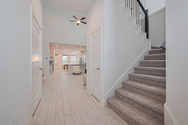 21307 Metallic Blue Dr, Cypress, TX 77433 - staircase featuring ceiling fan, a high ceiling, and wood finished floors
