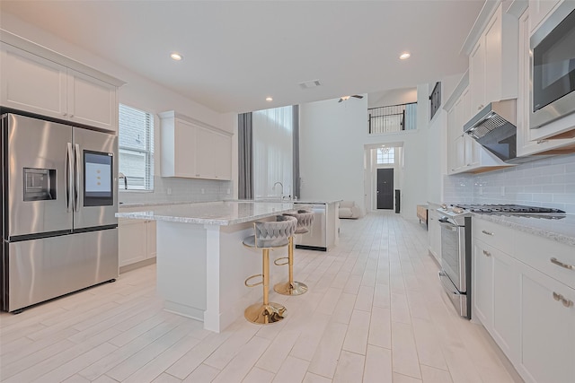 21307 Metallic Blue Dr, Cypress, TX 77433 - kitchen with stainless steel appliances, a kitchen breakfast bar, tasteful backsplash, plenty of natural light, and recessed lighting